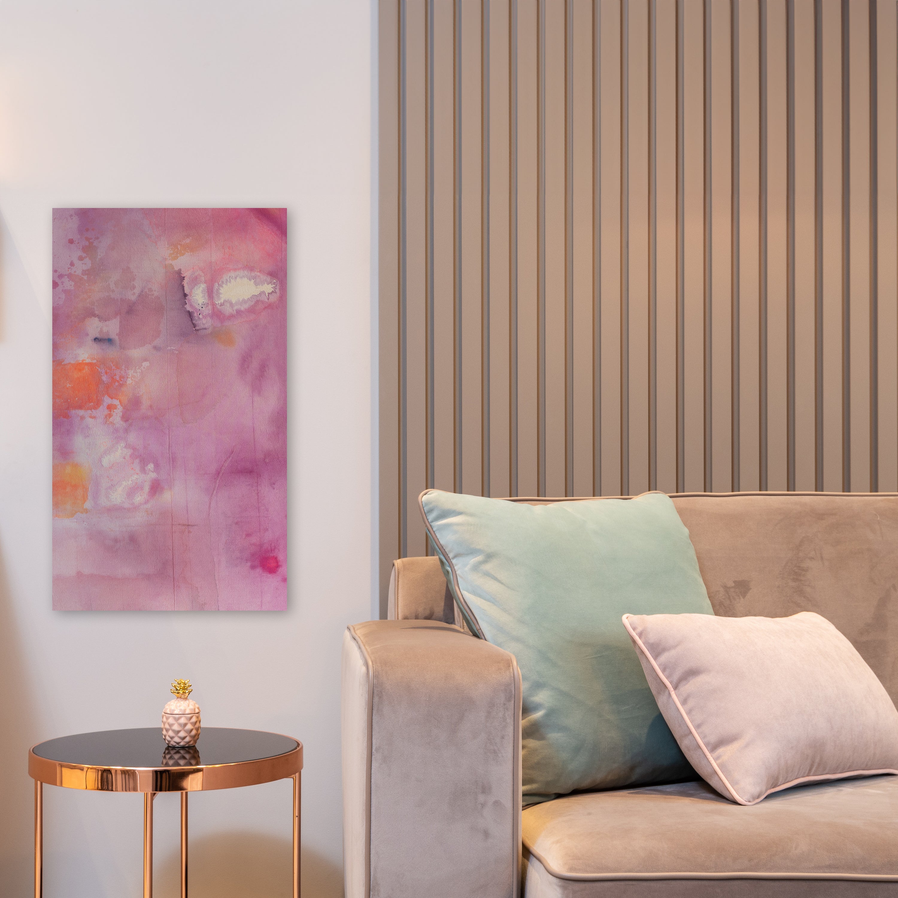 Purple and orange painting hangs above a side table, next to a couch.