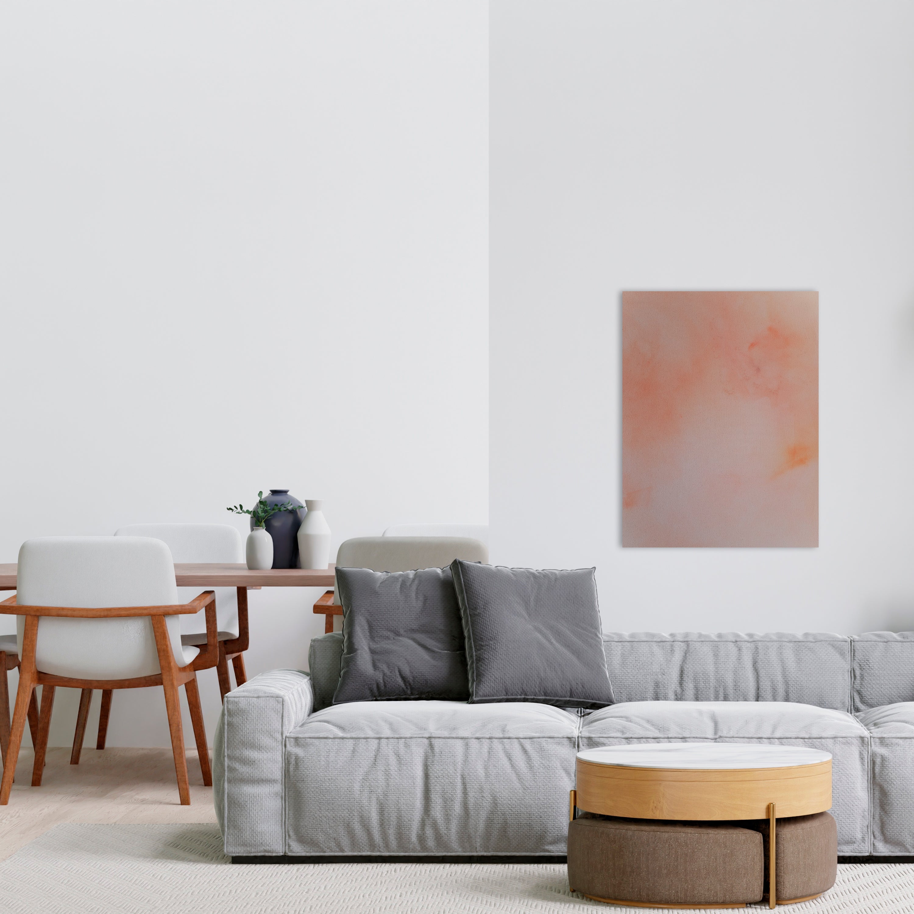 Pink and orange abstract painting hangs above a gray couch in a living room.