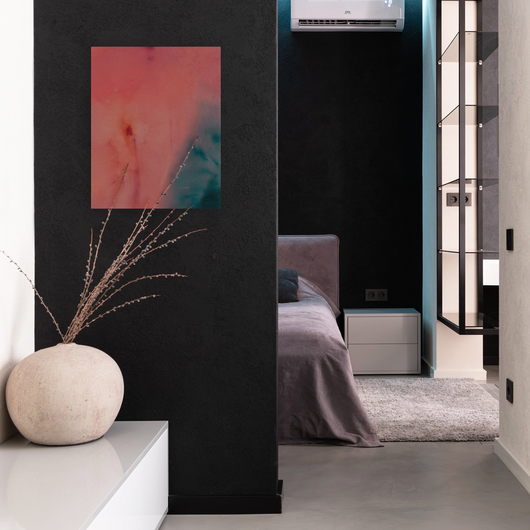 An abstract painting made with pink, purple, blue, and green washes of acrylic paint hangs on a black wall in a sleek home or hotel room.
